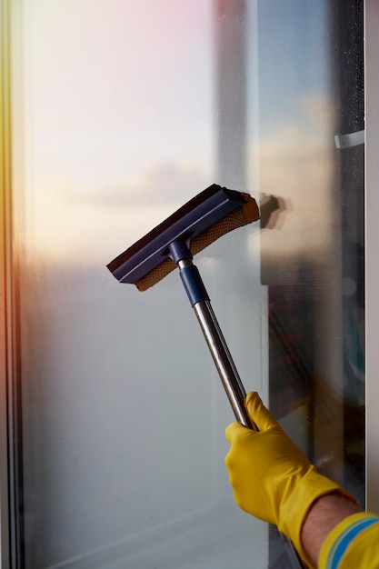 Huis schoonmaken in de lente Ramen wassen Huishoudelijke klusjes een man maakt zijn huis schoon