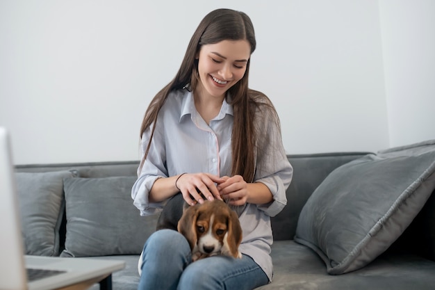 Huisdier eigenaar. Jonge donkerharige vrouw met een schattige puppy thuis