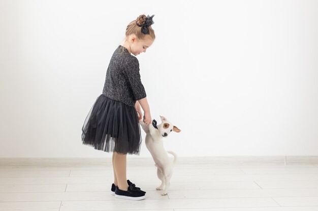 Huisdieren en dierlijk concept - Kindmeisje dat met puppy Jack Russell Terrier speelt.