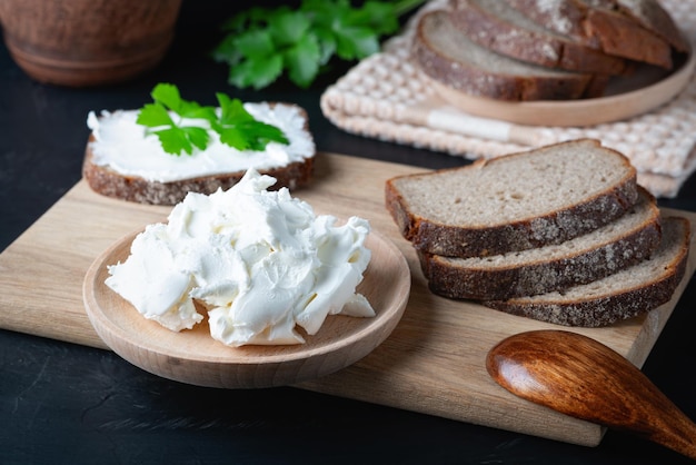 Huisgebakken brood op een houten snijplank met kwark en ricotta