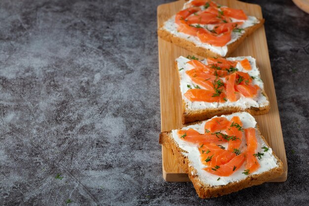 Huisgebakken brood op een houten snijplank met kwark zalm en kruiden