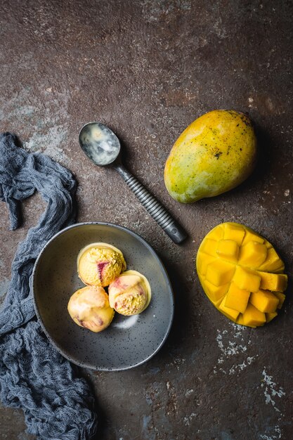 Huisgemaakt mango-ijs in een kom met vers fruit