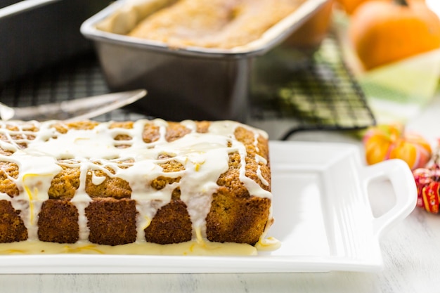 Huisgemaakt pompoenbrood met sinaasappelglazuur erop.