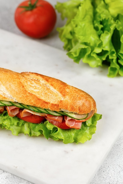 Huisgemaakt stokbrood met ham en groenten Sandwich met ham tomaat sla salade komkommer