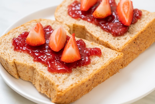 huisgemaakt volkoren brood met aardbeienjam en verse aardbeien