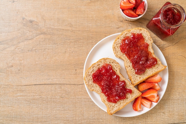 huisgemaakt volkorenbrood met aardbeienjam en verse aardbeien