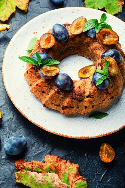 Huisgemaakte bananencake met pruimen. Zoete herfsttaart op witte achtergrond