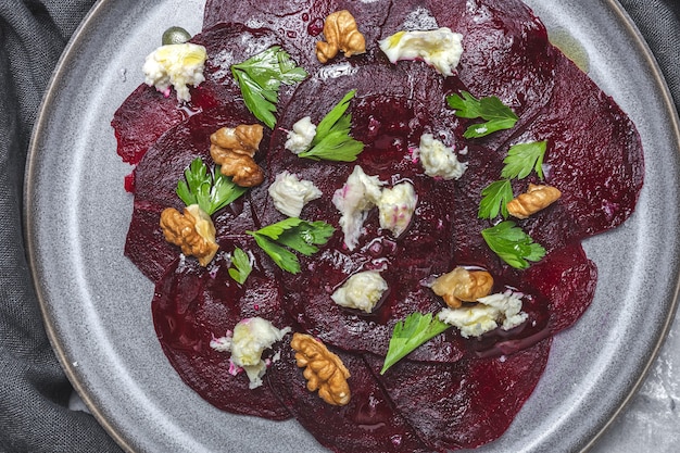 Foto huisgemaakte bietensalade met walnoten, mozzarella, peterselie en kerstomaatjes. veganistisch eten concept