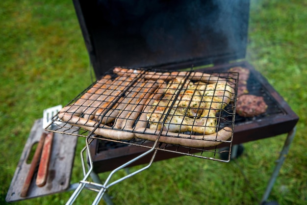 Foto huisgemaakte burgers op de grill met worstjes en kip