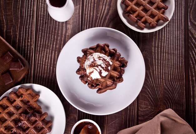 Huisgemaakte chocoladewafels met roomijs versierd chocoladesiroop