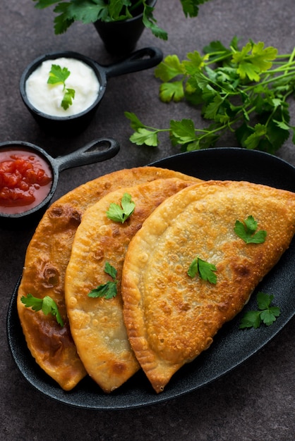 Huisgemaakte empanadas met vulling en tomatensaus