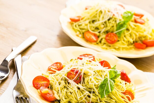 Huisgemaakte engelenhaarpasta met pestosaus en geroosterde kerstomaatjes.