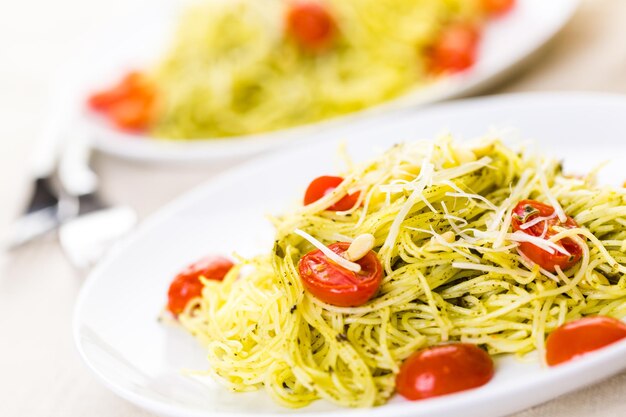 Huisgemaakte engelenhaarpasta met pestosaus en geroosterde kerstomaatjes.