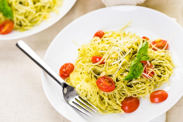 Huisgemaakte engelenhaarpasta met pestosaus en geroosterde kerstomaatjes.