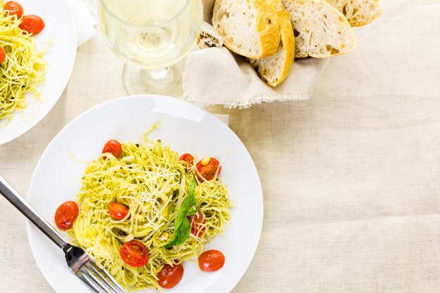 Huisgemaakte engelenhaarpasta met pestosaus en geroosterde kerstomaatjes.