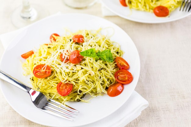 Huisgemaakte engelenhaarpasta met pestosaus en geroosterde kerstomaatjes.