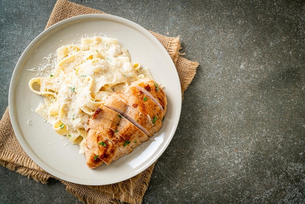 Foto huisgemaakte fettucine pasta witte romige saus met gegrilde kip