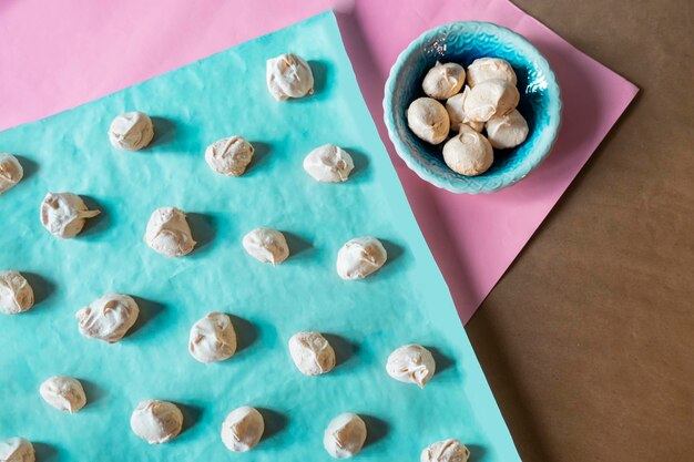 Huisgemaakte franse melkkleurige meringues op blauw papier