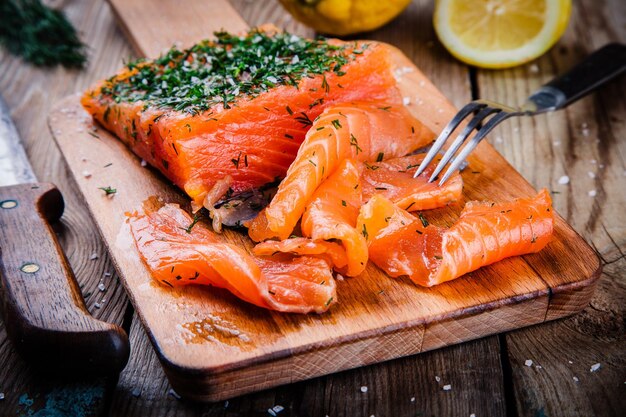 Huisgemaakte gerookte zalm met dille op een houten tafel