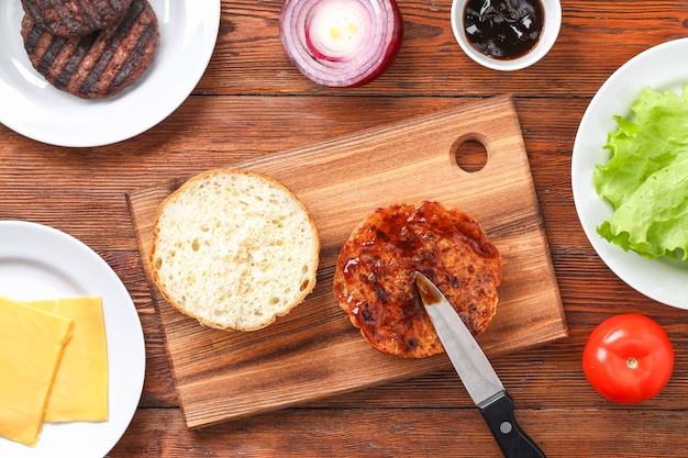 Huisgemaakte hamburger met kotelet, salade, ui, tomaat en kaas