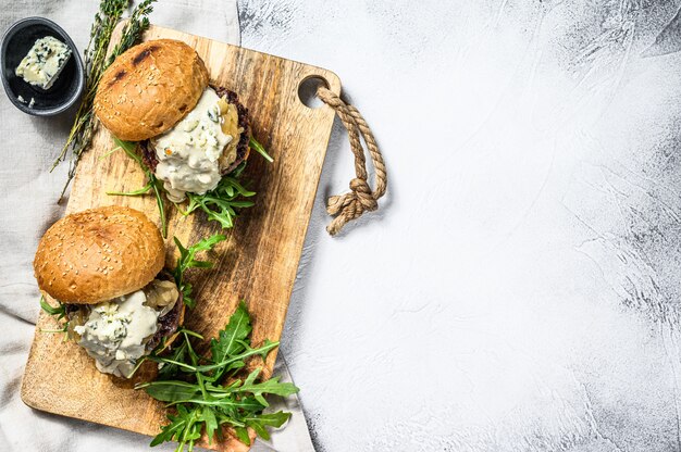 Huisgemaakte hamburger met schimmelkaas, gemarmerd rundvlees, uienmarmelade en rucola