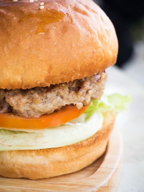 Huisgemaakte hamburger. Zijaanzicht van de close-up. Vers vlees, grillrundvlees, groenten en burgerbrood.