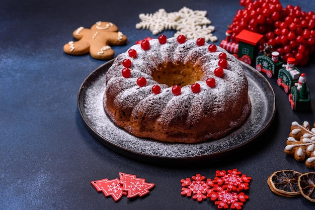 Huisgemaakte heerlijke ronde kersttaart met rode bessen op een keramisch bord