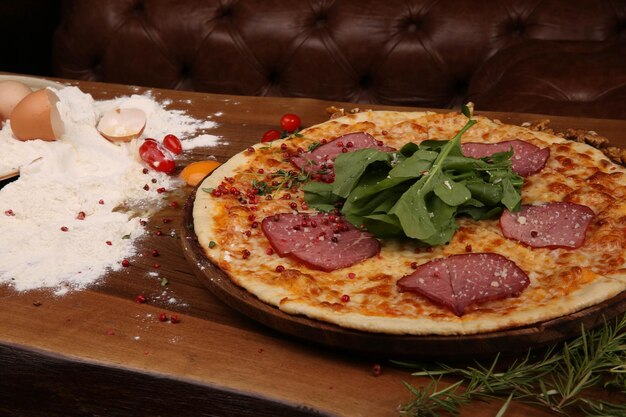 Huisgemaakte Italiaanse pizza met mozzarella kaas salami tomatensaus peper rucola en kruiden