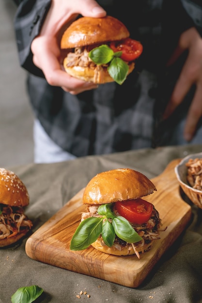 Huisgemaakte miniburgers met stoofvlees in handen