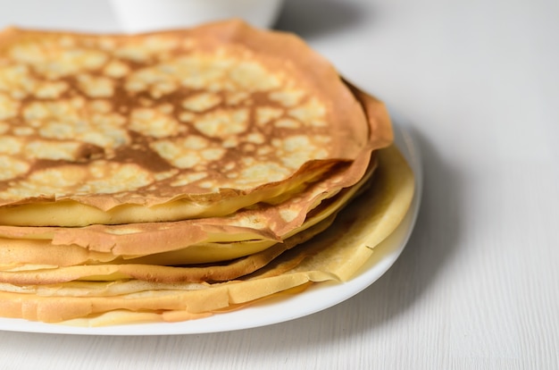 Huisgemaakte pannenkoeken op een wit bord met kwark