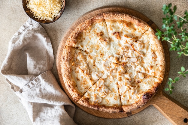 Huisgemaakte pizza met kip en kaas op witte saus