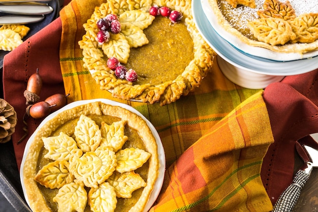 Huisgemaakte pompoentaarten met herfstbladeren.