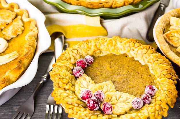 Huisgemaakte pompoentaarten met herfstbladeren.