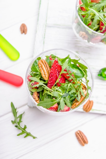 Huisgemaakte salade met aardbeien, pecannoten en rucola