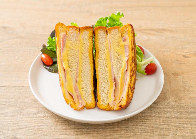 huisgemaakte sandwich ham kaas met salade op wit bord