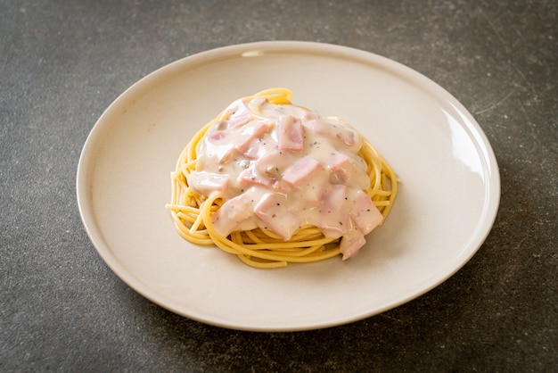 Huisgemaakte spaghetti witte roomsaus met ham. italiaanse eetstijl