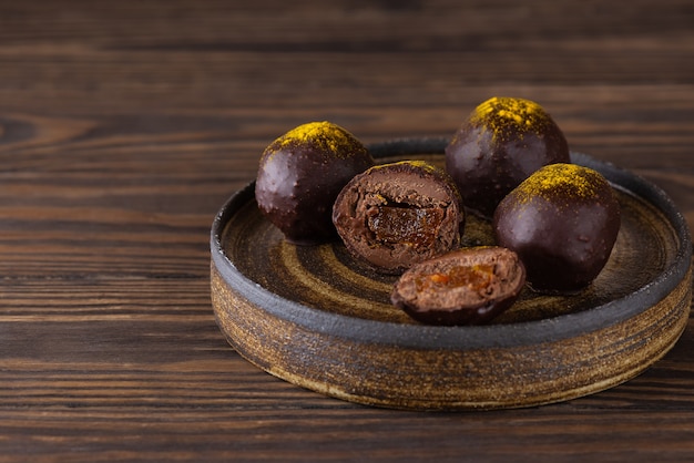 Huisgemaakte truffels met sinaasappelvulling op een bruine houten tafel suikergluten- en lactosevrij