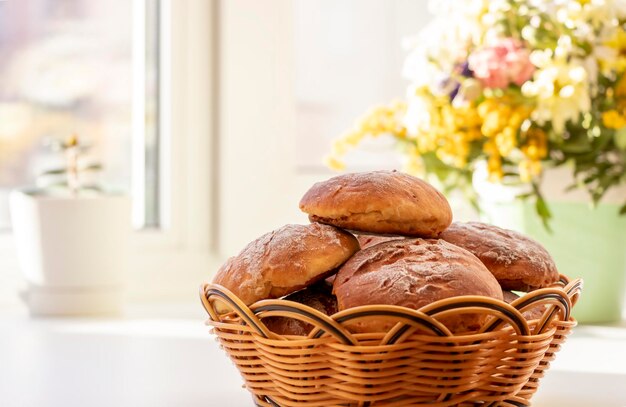 Huisgemaakte verse ronde broodjes met een krokant bruin korstje in een rieten mand