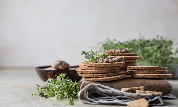 Huisgemaakte vlees- of kippenleverpastei met meergranencrackers en microgroen