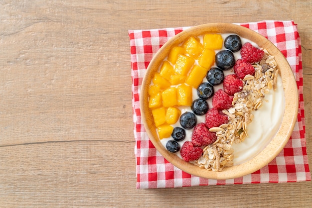 Huisgemaakte yoghurtkom met framboos, bosbes, mango en granola