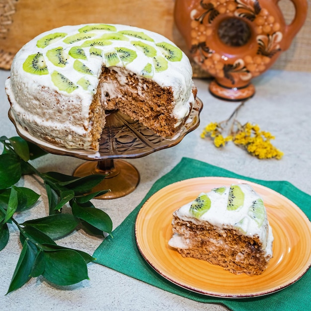 Huisgemaakte zoete cake met zure room-bananencrème gedecoreerd met kiwi