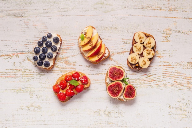 Huisgemaakte zomertoast met roomkaas, notenboter en fruit en bessen