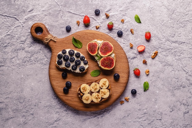 Huisgemaakte zomertoast met roomkaas, notenboter en fruit en bessen