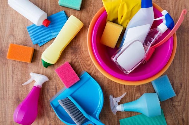 huishoudelijk werk, huishouden en huishoudelijk concept - bassin met schoonmaakspullen op houten vloer
