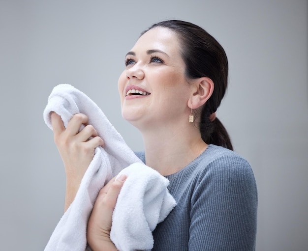 Huishoudelijke was en vrouw die handdoek vasthoudt en geniet van de frisse geur van wasmiddel voor het huishouden tegen een grijze achtergrond Glimlach van vrouwelijke schoonmaakster en het wassen of wassen in Oekraïne