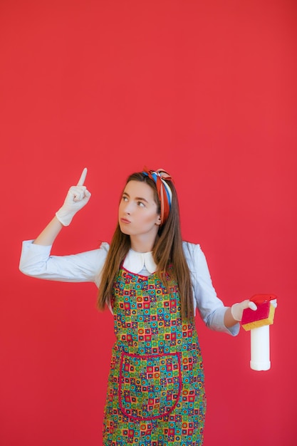 Huishoudster in uniform met schone spuitspons huishoudster of gelukkige vrouw die schoonmaakt met zeepfles