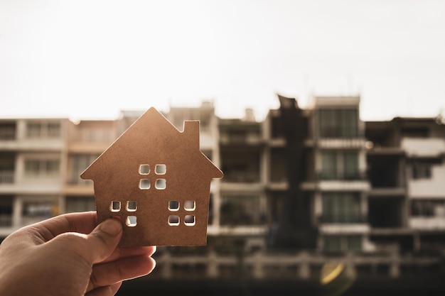 Foto huismodel in de hand van de makelaar van de woningverzekering