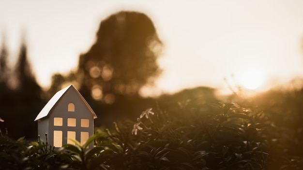 Foto huismodel op aardachtergrond, een symbool voor bouw, ecologie, lening, hypotheek, bezit of huis.