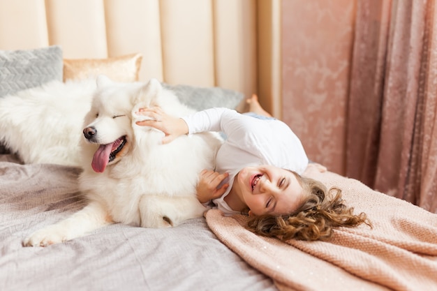 Huisportret van leuk kind die met hond op de bank koesteren