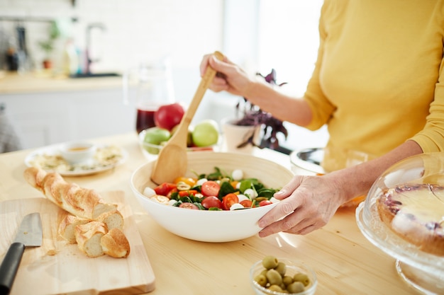 Huisvrouw die salade voor diner maakt